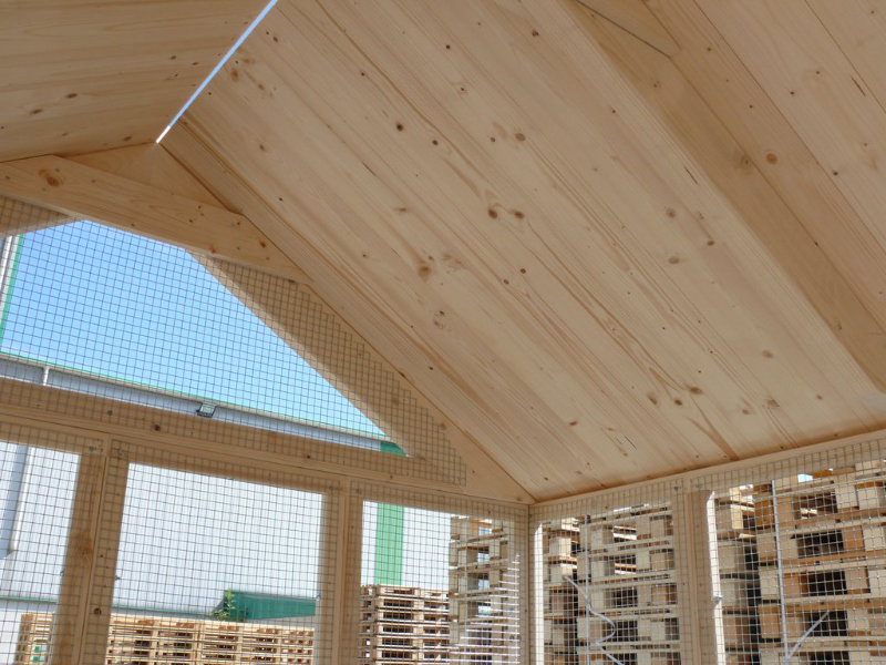 Detailaufnahme des mit Holz gedeckten Satteldach von innen